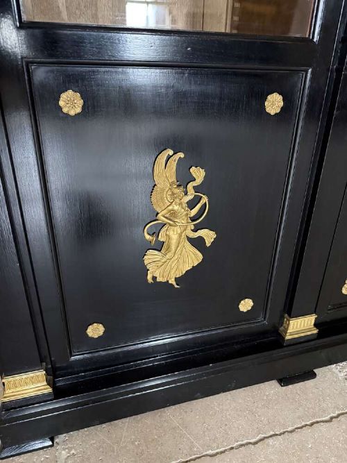 A large late 19th-century French Empire style ebonised bookcase with three arched glass doors, gilt bronze mounts, and light oak shelves. View IX