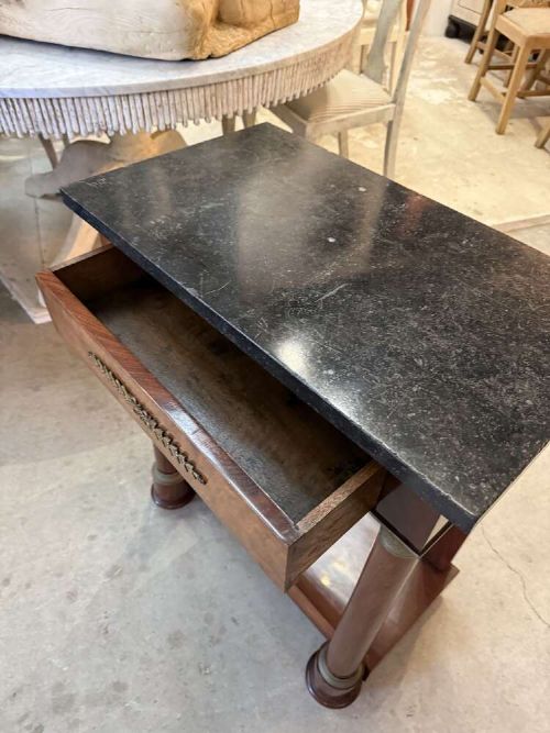 A small late nineteenth-century French Empire style mahogany console table featuring a black marble top, cylindrical column legs with metallic accents, a single frieze drawer with a brass laurel mount, and a lower shelf. View III