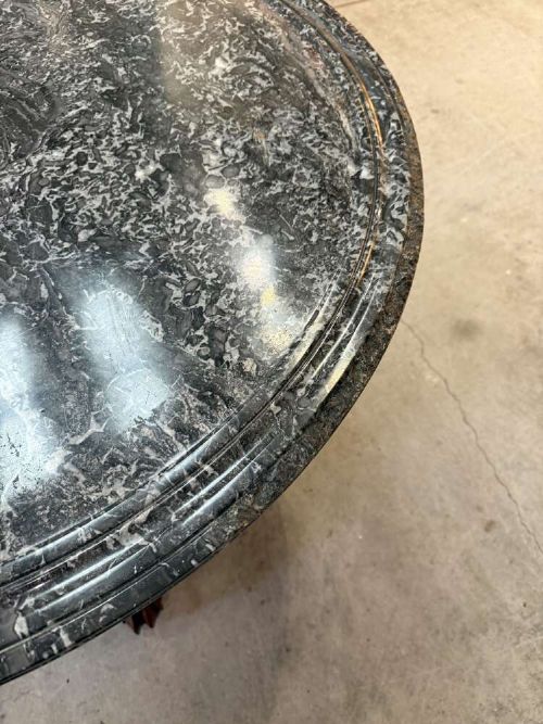 A 19th-century French circular gueridon table featuring a dark grey veined marble top resting on a carved mahogany pedestal base with carved feet. View III