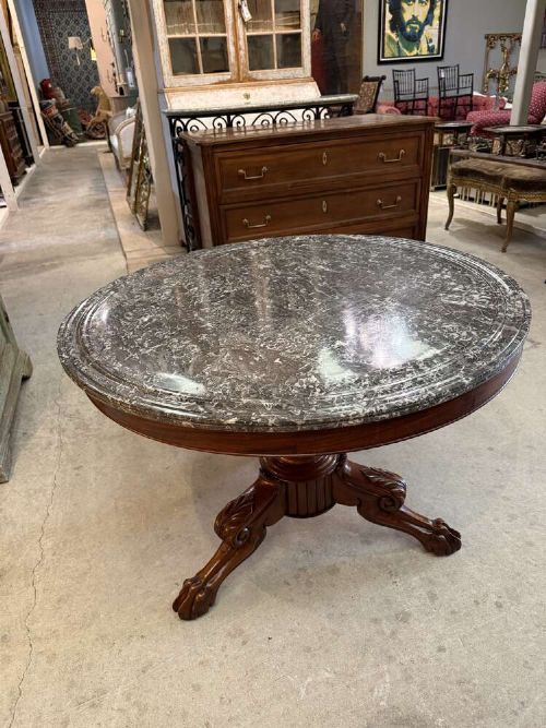 A 19th-century French circular gueridon table featuring a dark grey veined marble top resting on a carved mahogany pedestal base with carved feet. View VI
