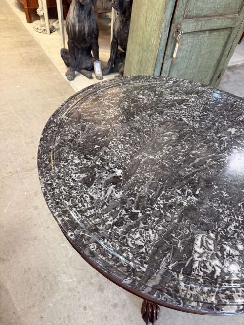 A 19th-century French circular gueridon table featuring a dark grey veined marble top resting on a carved mahogany pedestal base with carved feet. View VII