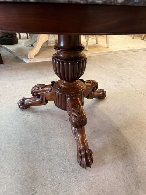 A 19th-century French circular gueridon table featuring a dark grey veined marble top resting on a carved mahogany pedestal base with carved feet. View X