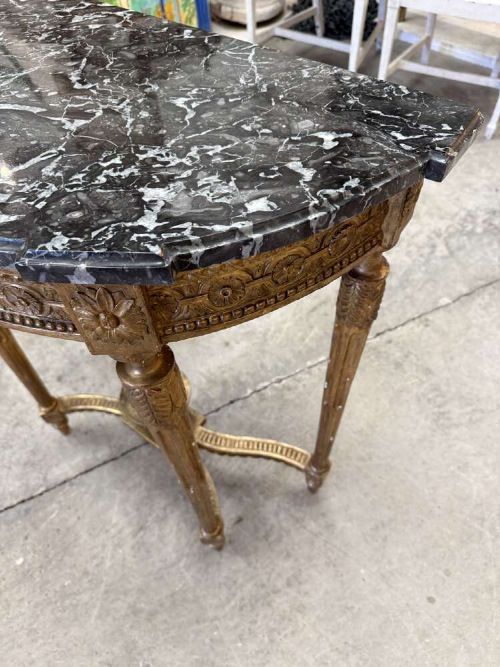 A late 19th-century French Louis XVI style demi-lune console table featuring a dark marble top, carved gilded legs, and a central urn finial. View IV