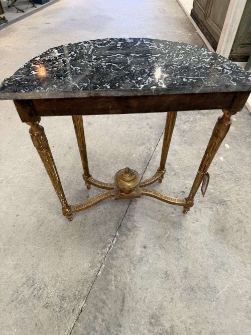 A late 19th-century French Louis XVI style demi-lune console table featuring a dark marble top, carved gilded legs, and a central urn finial. View VII