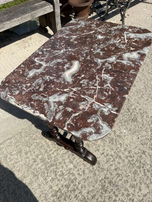 A 19th-century French table a gibier featuring a red and grey veined marble top resting on a dark turned timber base with a low stretcher. View VI