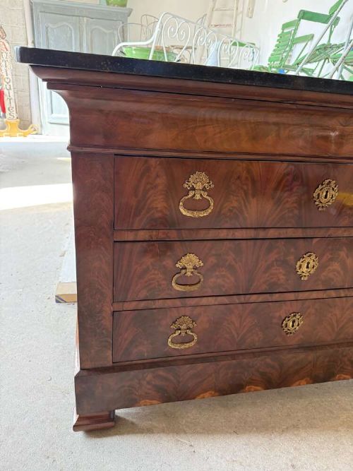 A nineteenth-century mahogany commode featuring three drawers with decorative brass handles and a dark marble top. View II