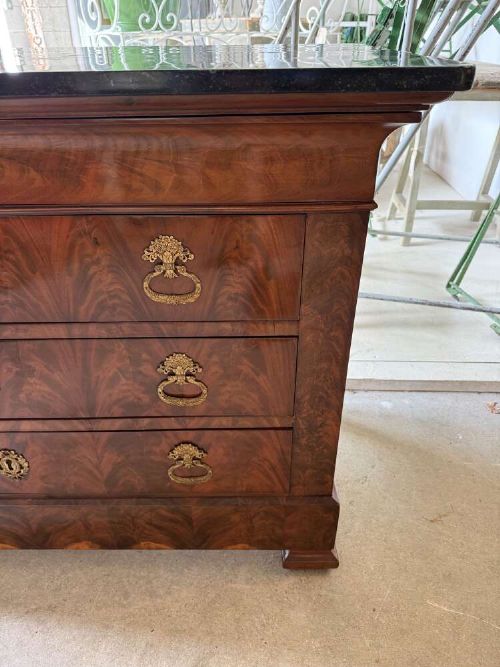 A nineteenth-century mahogany commode featuring three drawers with decorative brass handles and a dark marble top. View IV