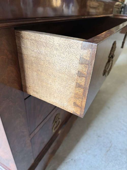 A nineteenth-century mahogany commode featuring three drawers with decorative brass handles and a dark marble top. View VII