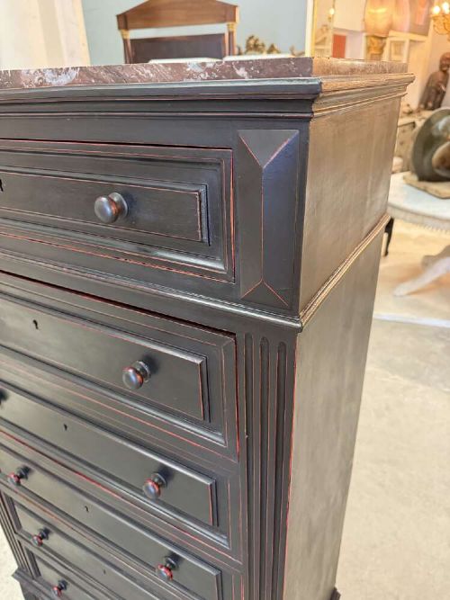 A tall narrow black ebonised chest of drawers featuring seven moulded drawers, turned wooden knobs, and a dark marble top. View II