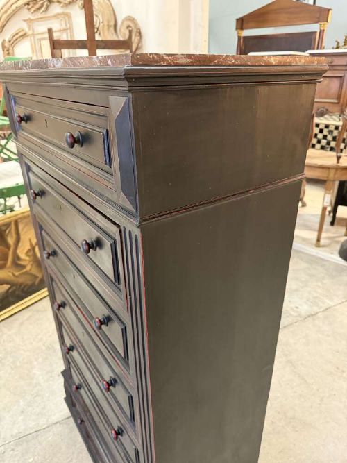 A tall narrow black ebonised chest of drawers featuring seven moulded drawers, turned wooden knobs, and a dark marble top. View III
