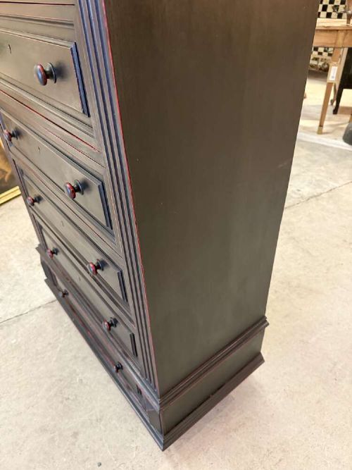 A tall narrow black ebonised chest of drawers featuring seven moulded drawers, turned wooden knobs, and a dark marble top. View IV