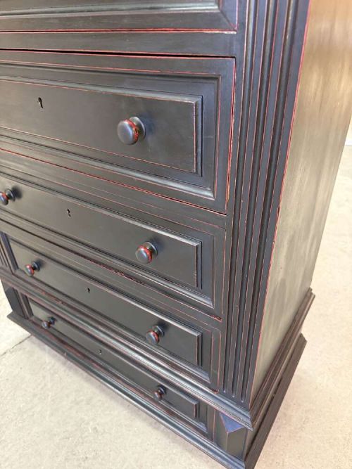 A tall narrow black ebonised chest of drawers featuring seven moulded drawers, turned wooden knobs, and a dark marble top. View V