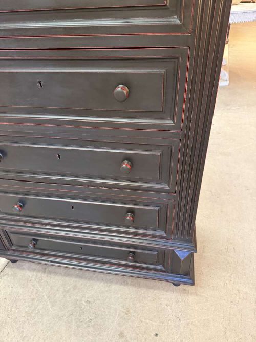 A tall narrow black ebonised chest of drawers featuring seven moulded drawers, turned wooden knobs, and a dark marble top. View VI