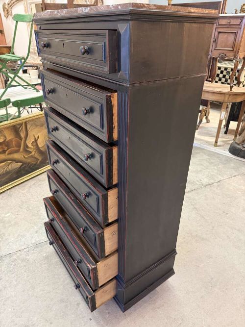 A tall narrow black ebonised chest of drawers featuring seven moulded drawers, turned wooden knobs, and a dark marble top. View VII