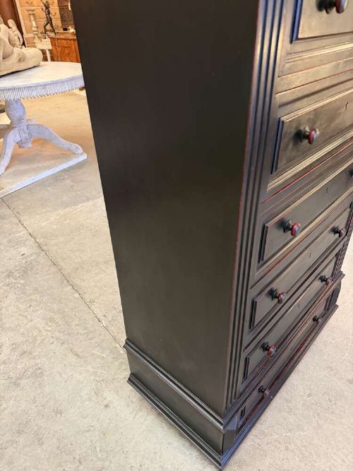 A tall narrow black ebonised chest of drawers featuring seven moulded drawers, turned wooden knobs, and a dark marble top. View IX
