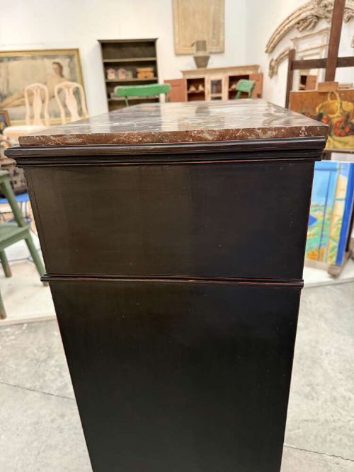 A tall narrow black ebonised chest of drawers featuring seven moulded drawers, turned wooden knobs, and a dark marble top. View XII