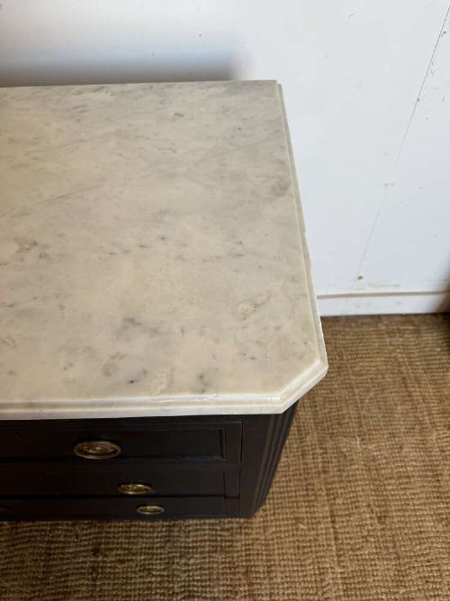 A 19th-century French three-drawer chest of drawers painted black with a white marble top and brass ring handles. View V