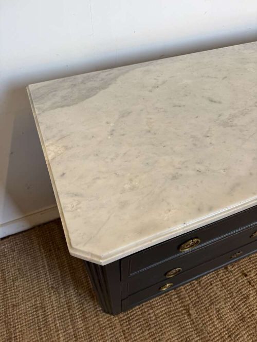 A 19th-century French three-drawer chest of drawers painted black with a white marble top and brass ring handles. View VII