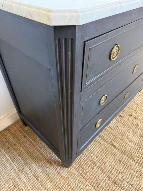 A 19th-century French three-drawer chest of drawers painted black with a white marble top and brass ring handles. View VIII