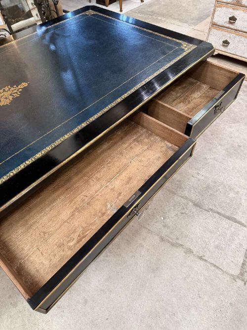 A 19th-century French ebonised writing desk with a black leather inset top, gilt-tooled border, three frieze drawers, brass mounts, and tapered fluted legs. View VII
