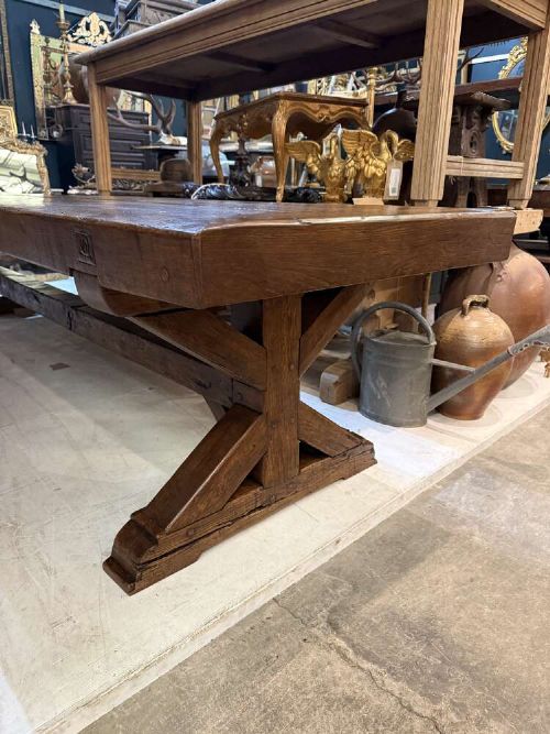 A long late 19th-century French oak refectory table featuring a thick plank top with cleated ends resting on sturdy trestle legs and a stretcher base. View III
