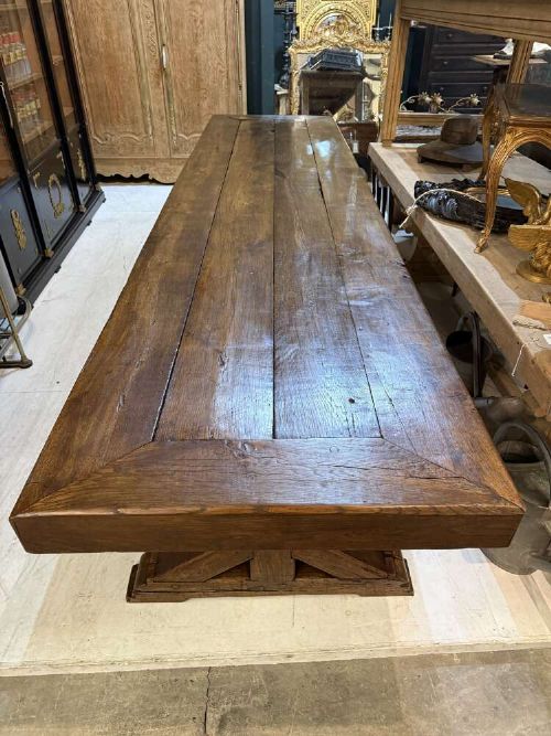 A long late 19th-century French oak refectory table featuring a thick plank top with cleated ends resting on sturdy trestle legs and a stretcher base. View IV