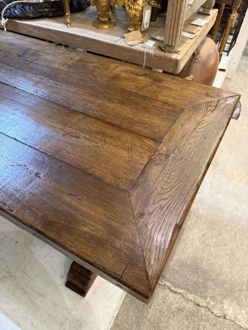 A long late 19th-century French oak refectory table featuring a thick plank top with cleated ends resting on sturdy trestle legs and a stretcher base. View V