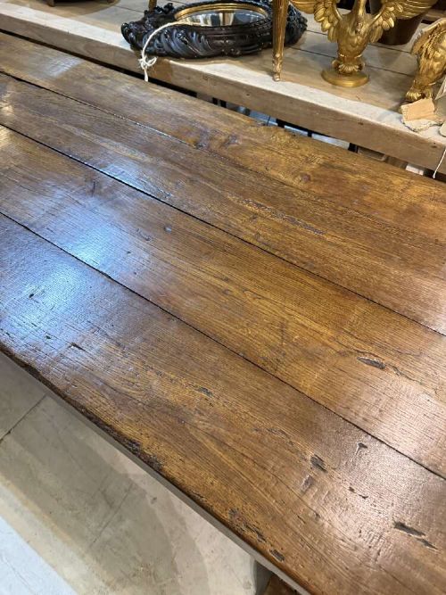 A long late 19th-century French oak refectory table featuring a thick plank top with cleated ends resting on sturdy trestle legs and a stretcher base. View VI