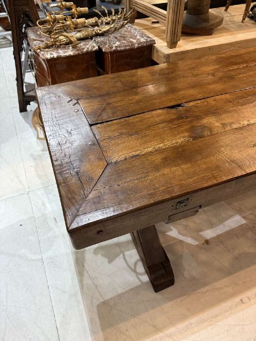 A long late 19th-century French oak refectory table featuring a thick plank top with cleated ends resting on sturdy trestle legs and a stretcher base. View VII