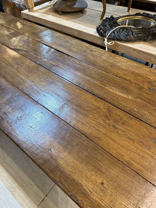 A long late 19th-century French oak refectory table featuring a thick plank top with cleated ends resting on sturdy trestle legs and a stretcher base. View XI