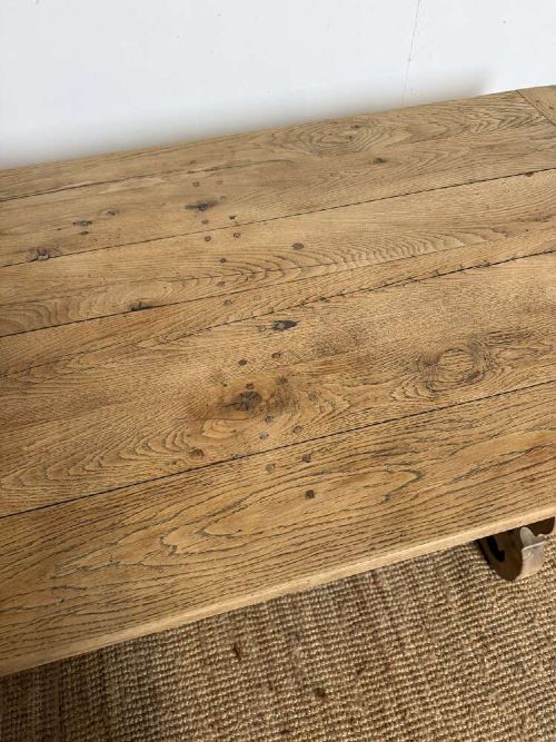 A long scrubbed oak refectory table with carved trestle legs connected by a central curved wrought iron scroll stretcher. View III