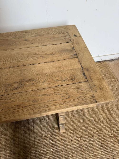 A long scrubbed oak refectory table with carved trestle legs connected by a central curved wrought iron scroll stretcher. View IV