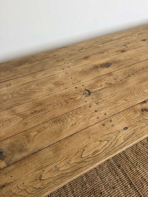 A long scrubbed oak refectory table with carved trestle legs connected by a central curved wrought iron scroll stretcher. View V