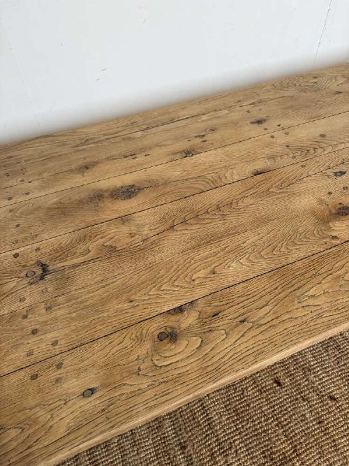A long scrubbed oak refectory table with carved trestle legs connected by a central curved wrought iron scroll stretcher. View VI