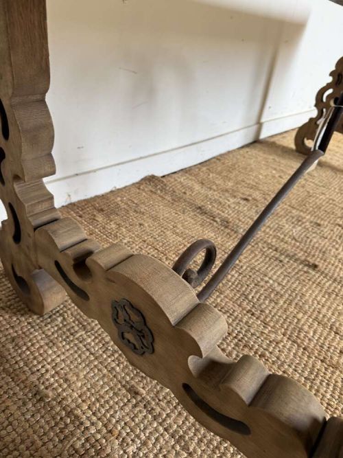 A long scrubbed oak refectory table with carved trestle legs connected by a central curved wrought iron scroll stretcher. View IX