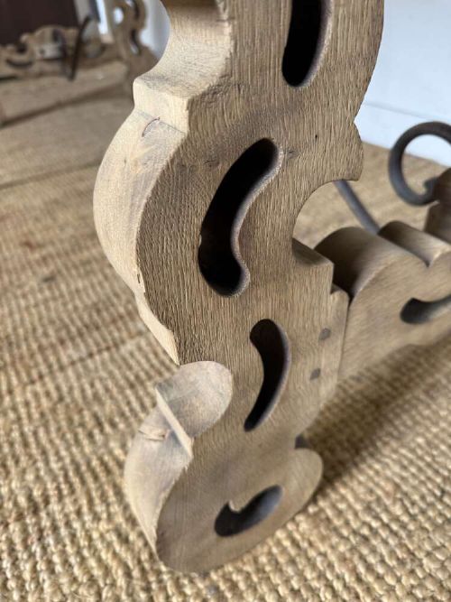 A long scrubbed oak refectory table with carved trestle legs connected by a central curved wrought iron scroll stretcher. View XIV