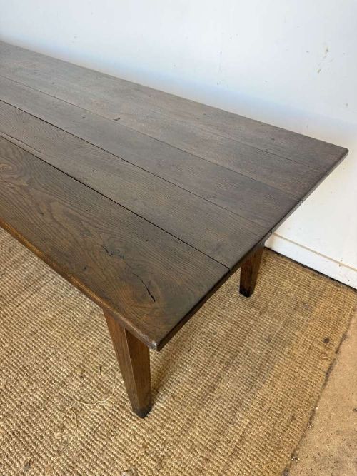 A long dark oak French farmhouse dining table featuring a plank top surface and four tapered square legs. View II