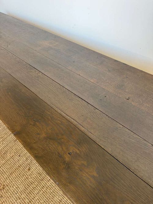 A long dark oak French farmhouse dining table featuring a plank top surface and four tapered square legs. View V