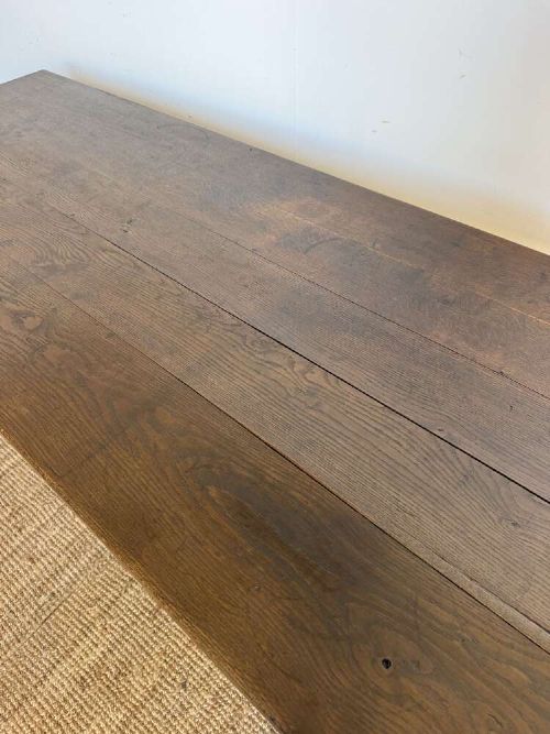 A long dark oak French farmhouse dining table featuring a plank top surface and four tapered square legs. View VI