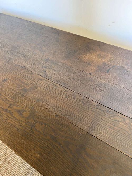 A long dark oak French farmhouse dining table featuring a plank top surface and four tapered square legs. View VII