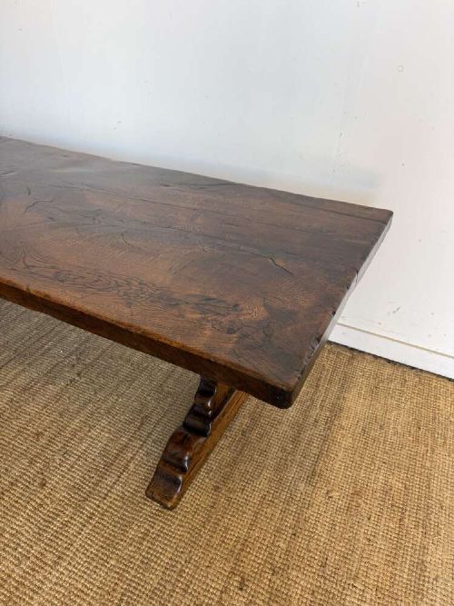 An early 20th century French dark oak refectory table featuring a single plank top supported by a pegged trestle base with a central stretcher. View II