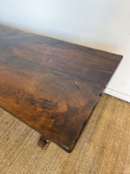 An early 20th century French dark oak refectory table featuring a single plank top supported by a pegged trestle base with a central stretcher. View IV