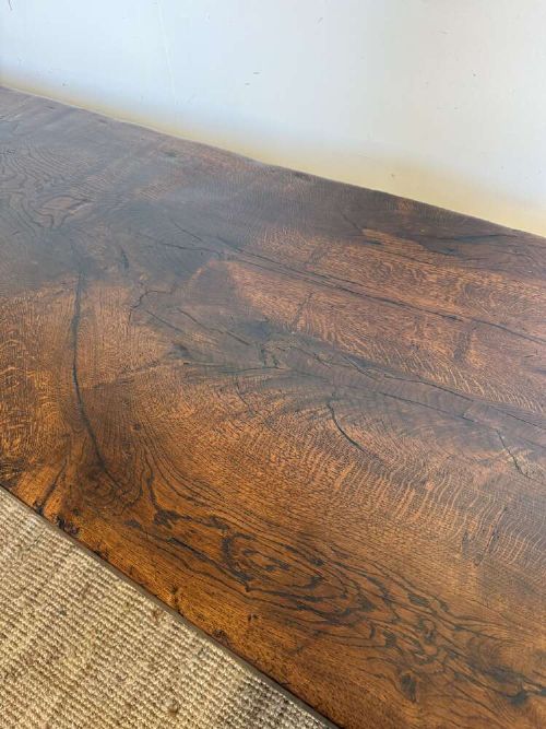An early 20th century French dark oak refectory table featuring a single plank top supported by a pegged trestle base with a central stretcher. View V