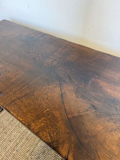 An early 20th century French dark oak refectory table featuring a single plank top supported by a pegged trestle base with a central stretcher. View VI