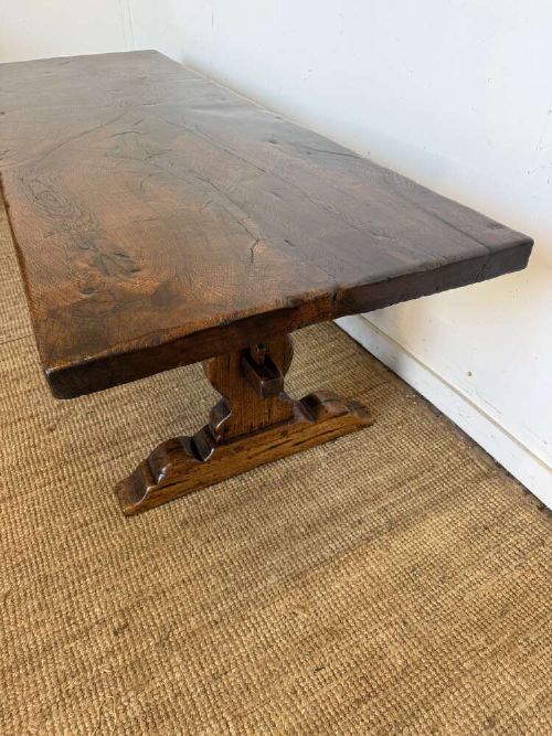 An early 20th century French dark oak refectory table featuring a single plank top supported by a pegged trestle base with a central stretcher. View VII