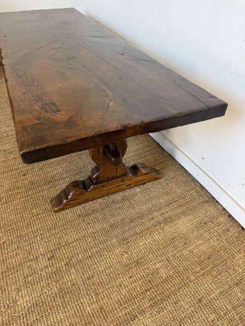 An early 20th century French dark oak refectory table featuring a single plank top supported by a pegged trestle base with a central stretcher. View IX