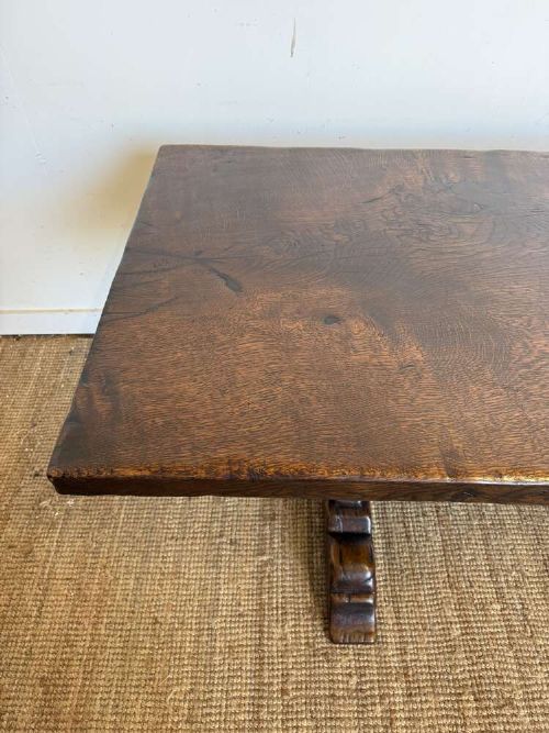 An early 20th century French dark oak refectory table featuring a single plank top supported by a pegged trestle base with a central stretcher. View X
