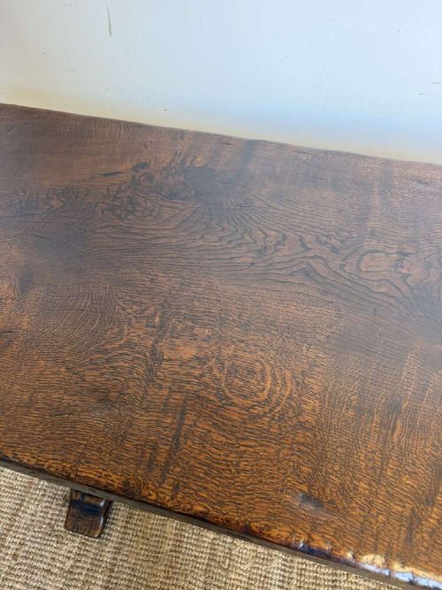 An early 20th century French dark oak refectory table featuring a single plank top supported by a pegged trestle base with a central stretcher. View XI