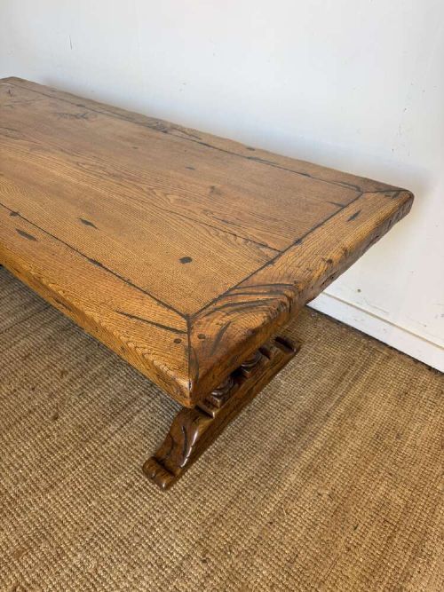 An early 20th-century oak refectory dining table featuring a rectangular framed plank top supported by turned legs on a trestle base with a stretcher rail. View II