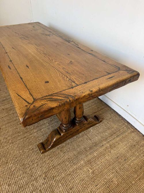 An early 20th-century oak refectory dining table featuring a rectangular framed plank top supported by turned legs on a trestle base with a stretcher rail. View III